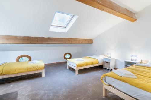 - 2 lits dans une chambre avec des draps jaunes dans l'établissement Le Relais de Bellemaison, à Montfrin