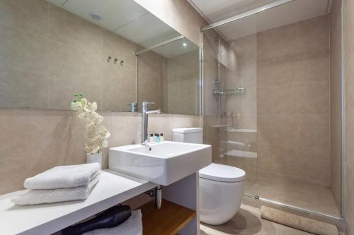 y baño con lavabo, aseo y espejo. en 3-bedroom penthouse with terrace in Eixample, en Barcelona