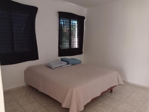 ein Bett mit zwei Kissen auf einem Zimmer in der Unterkunft Dormir in Boca Chica
