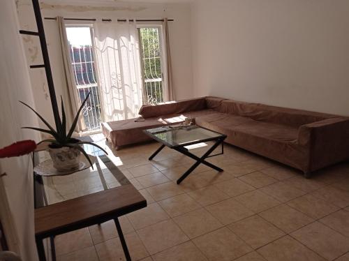 sala de estar con sofá y mesa de cristal en Dormir, en Boca Chica