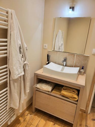 a bathroom with a sink and a mirror at Maison rénovée typique, au calme, piscine. in La Courtète