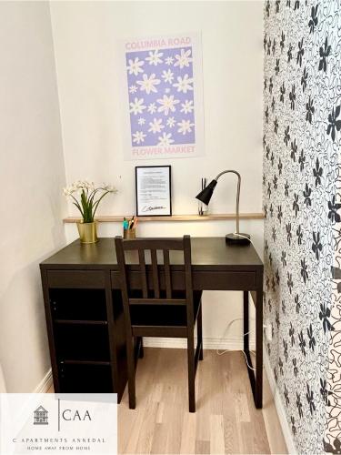 a desk with a chair and a lamp at C Apartments Annedal in Gothenburg