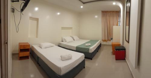 a hotel room with two beds and a mirror at AW Connect Airport in Bogotá