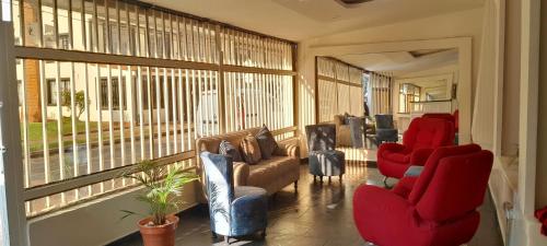 a living room with red chairs and a large window at AW Connect Airport in Bogotá