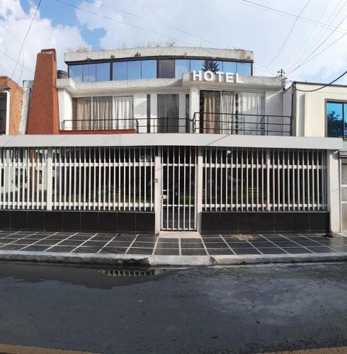 a white fence in front of a house at AW Connect Airport in Bogotá