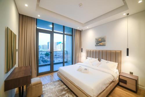 a bedroom with a large bed and a large window at Diamond Jumeirah Garden City 1BR Apt in Dubai
