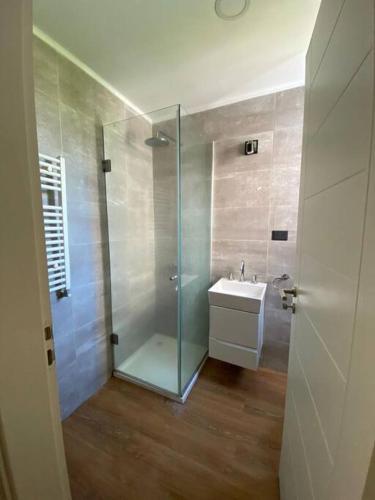 a bathroom with a glass shower and a sink at Duplex San Martín in Lobos