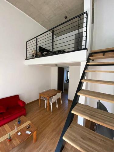 a living room with a staircase and a red couch at Duplex San Martín in Lobos