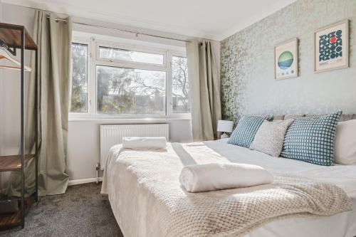 ein Schlafzimmer mit einem weißen Bett und einem Fenster in der Unterkunft Comfy Home Ideal for Groups - Free Parking in Bedford