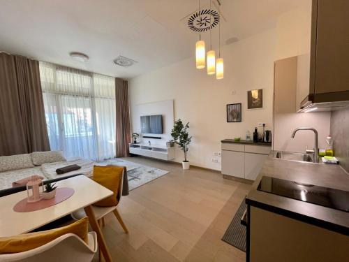 eine Küche und ein Wohnzimmer mit einem Tisch und einem Sofa in der Unterkunft NEW, BEAUTIFUL APT WITH PARKING IN BEST LOCATION! in Bratislava