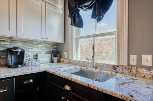 eine Küchentheke mit einem Waschbecken und einem Fenster in der Unterkunft Movie Lover's Gem - Steps from Metro & the Capitol! in Washington