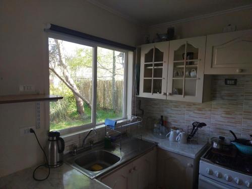 cocina con fregadero y ventana en Cabaña Campestre, en Osorno