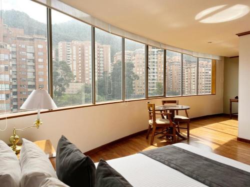 Hotel Bogotá Regency Usaquén في بوغوتا: غرفة نوم بسرير وإطلالة على مدينة