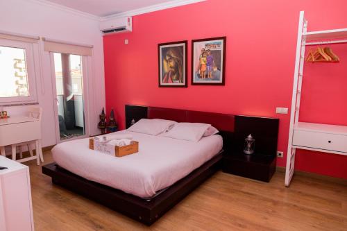 a red bedroom with a bed with a box on it at Casa Vila Rosa in Peso da Régua