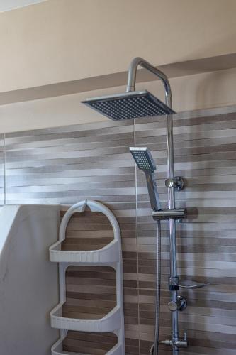 a shower in a bathroom with a striped wall at Villa Daniela in Neokhórion