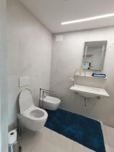 a bathroom with a white toilet and a sink at Ferienwohnungen JoJaSa in Laces