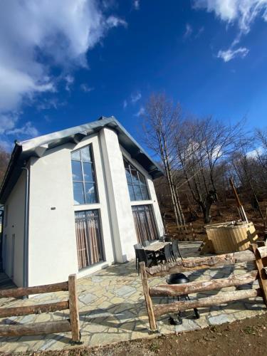 a small white building with a table and a fence at Luxos Villa in Ferizaj