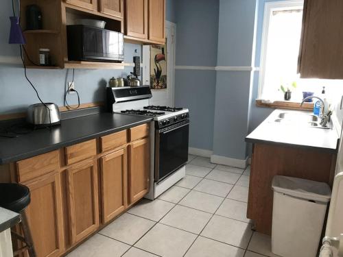 a kitchen with wooden cabinets and a stove top oven at Bryn Mawr Guest Suites in Bryn Mawr