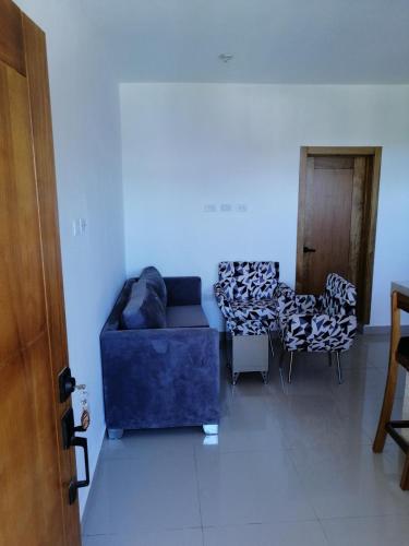 a living room with a blue couch and chairs at Apartamento JGB in Sosúa