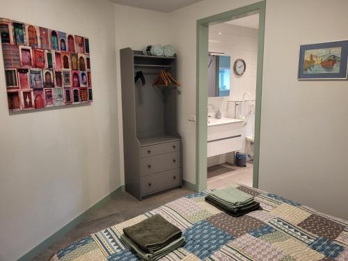 een badkamer met een bed, een wastafel en een spiegel bij B & B De Tocht in Berkhout