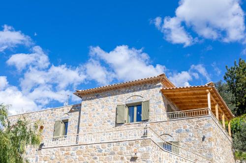 a stone house with a blue sky in the background at Villa Daniela Studio in Neokhórion