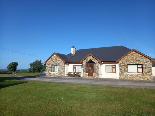 a large house with a grassy field in front of it at Four Seasons in Waterford