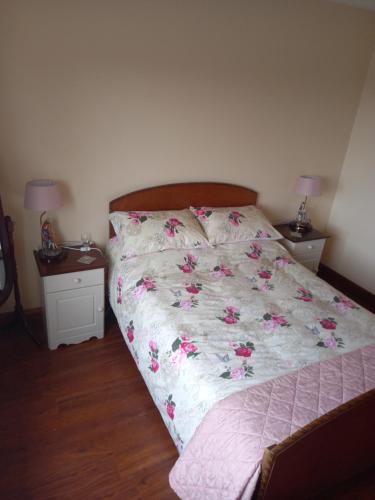 a bedroom with a bed with pink flowers on it at Four Seasons in Waterford