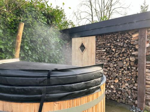 a black hammock in front of a wooden fence at In de bocht - Hottub Sauna in Gemonde