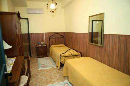 a hotel room with two beds and a mirror at B&B Villa el Tango in Villa San Giovanni