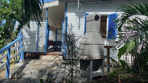 a house with a statue in front of a porch at Le Colibri, belle vue mer, accés direct à la plage, SPA privatif in Bouillante