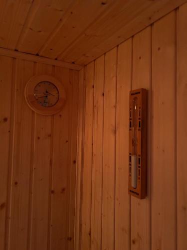 a wooden wall with a clock on a wall at In de bocht - Hottub Sauna in Gemonde