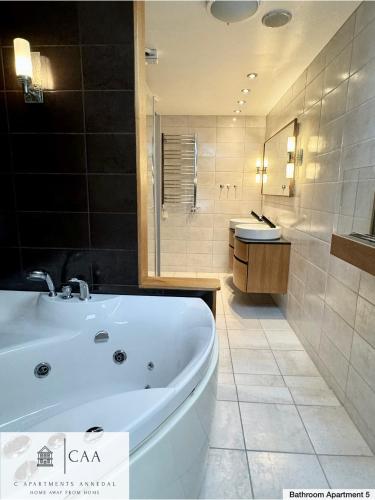 a large bathroom with a tub and a sink at C Apartments Annedal in Gothenburg
