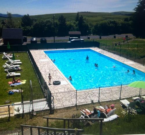 une grande piscine avec des gens dans l'eau dans l'établissement Super Besse chez Sophie 2ch, séjour, wifi, 2tv, rdc, terrasse, parc, piscine, pkg, à Besse-et-Saint-Anastaise