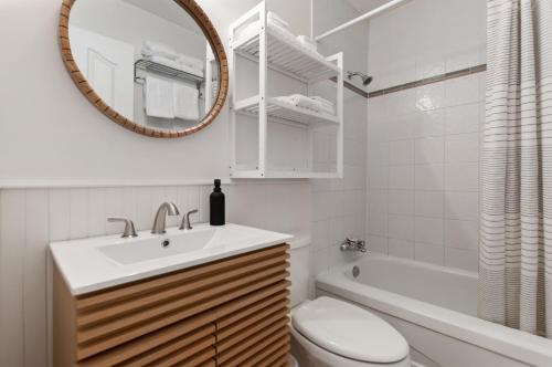 a bathroom with a sink and a toilet and a mirror at Okanagan Lakefront Resort in Penticton