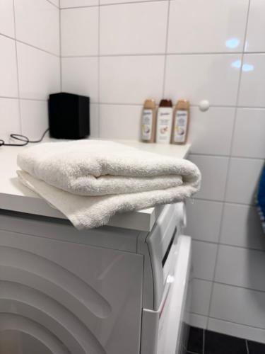 a white towel sitting on top of a washing machine at Fresh Apartment in Stockholm