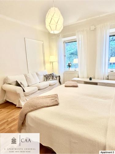 a white room with two beds and a couch at C Apartments Annedal in Gothenburg