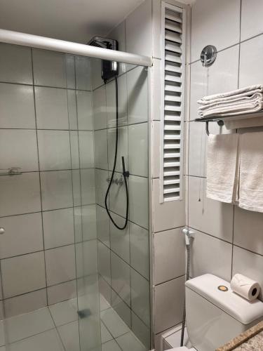 y baño con ducha de cristal y aseo. en Gran Lençóis Flat Residence en Barreirinhas