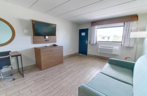 a living room with a couch and a tv at Seashire Inn & Suites in Virginia Beach