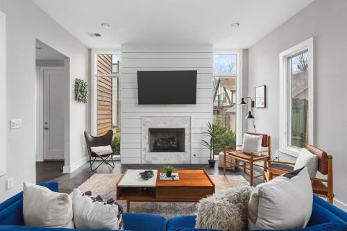 a living room with a blue couch and a fireplace at Modern Luxury Rooftop Deck, 3 mi to Downtown in Nashville