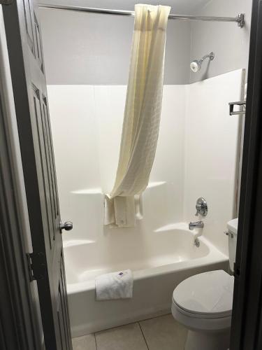 a bathroom with a white tub and a toilet at Studio 6 Suites Louisville KY Airport/Expo Center in Louisville