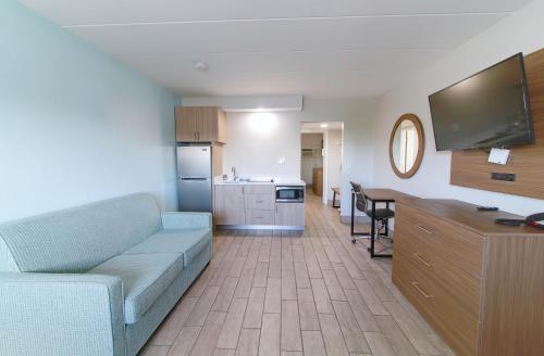 a living room with a couch and a kitchen at Seashire Inn & Suites in Virginia Beach