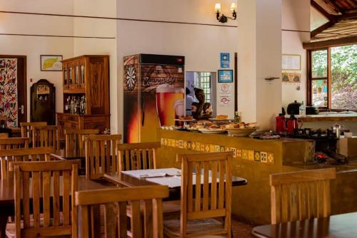 un restaurant avec des tables et des chaises en bois et un comptoir dans l'établissement Pousada da Mata, à Cunha
