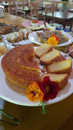 a table with three plates of bread and flowers on it at Pousada da Mata in Cunha