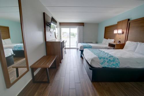 een hotelkamer met 2 bedden en een spiegel bij Seashire Inn & Suites in Virginia Beach