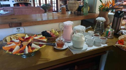 une table avec un bol de fruits et une assiette de lait dans l'établissement Pousada da Mata, à Cunha