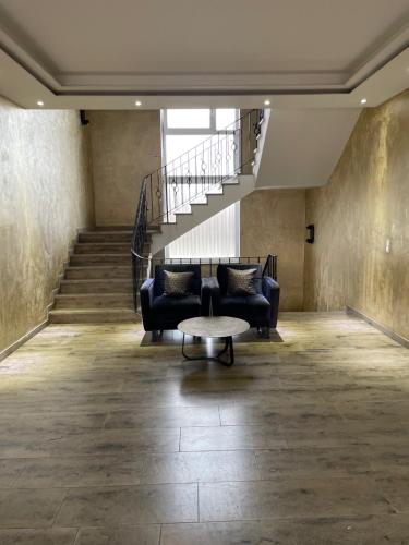 a living room with a couch and a staircase at Gastpark Hotel in Manching