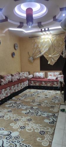 a living room with couches and a rug at رياض النخيل in Aïn el Apuda