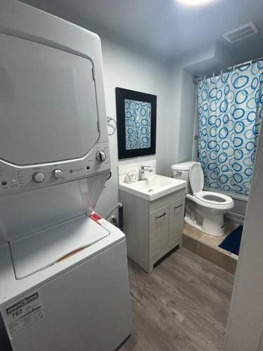 a bathroom with a white sink and a toilet at Cute Highland Park Entire Unit B in Calgary