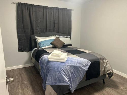 ein Schlafzimmer mit einem Bett mit zwei Handtüchern darauf in der Unterkunft Cute Highland Park Entire Unit B in Calgary