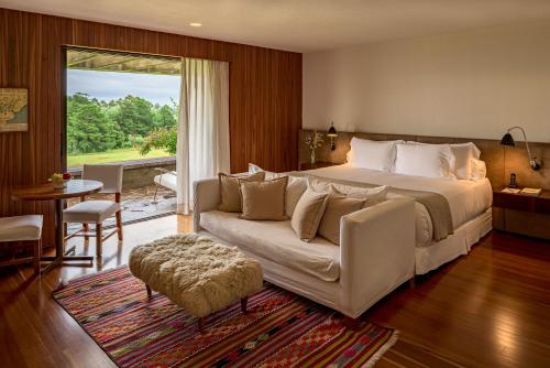 a bedroom with a large bed and a couch at Hotel Fasano Punta del Este in Punta del Este